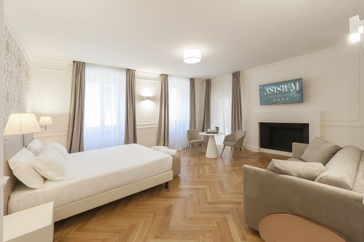 Bright and welcoming room at Asisium Boutique Hotel, featuring simple furnishings and a city view.