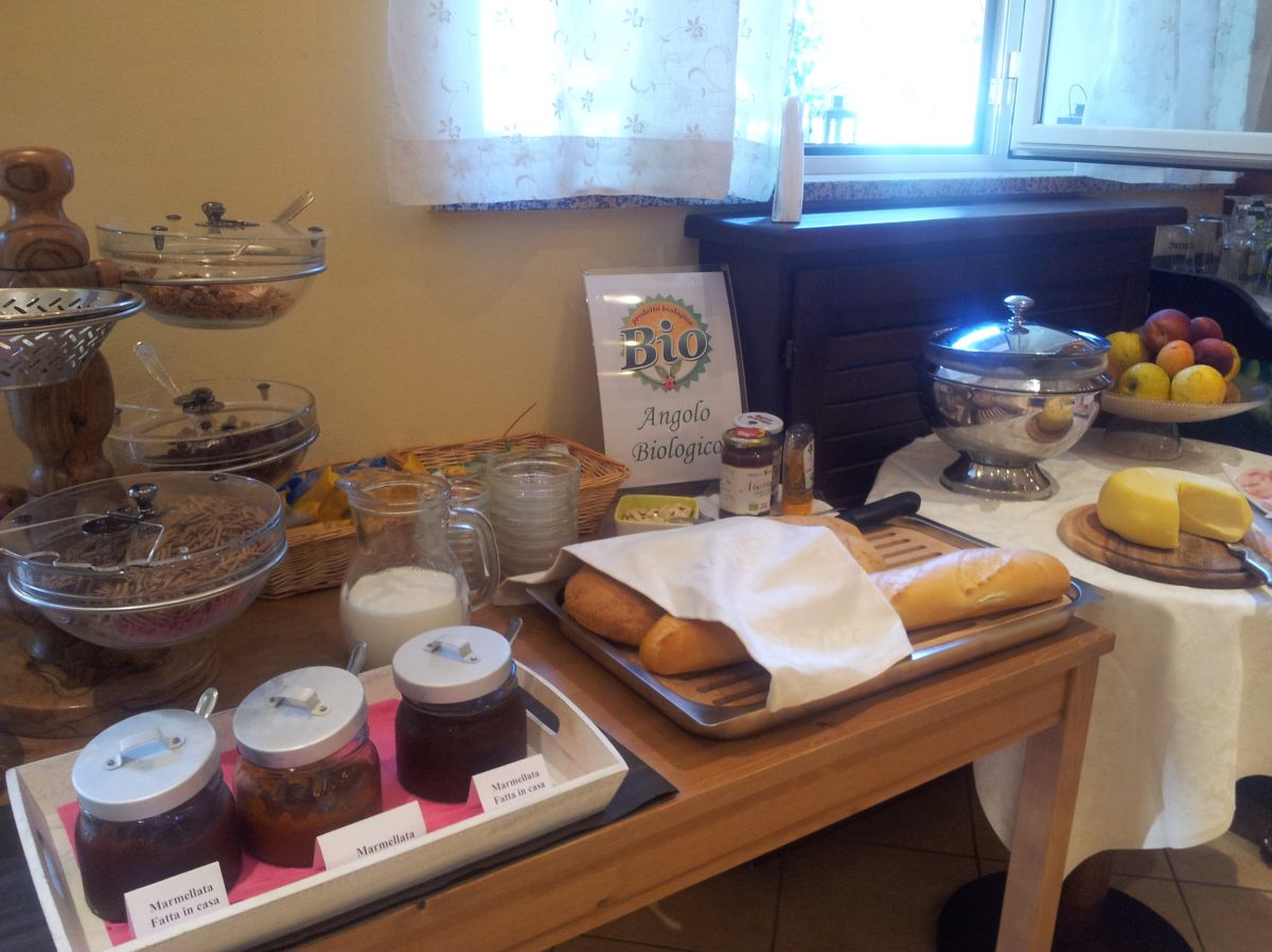 A buffet featuring organic foods like jams, milk, bread, and fresh fruits for a light breakfast.