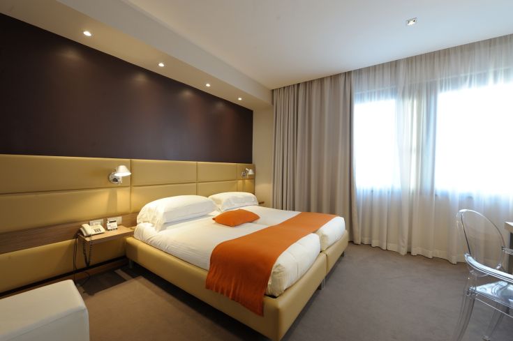 Cozy hotel room with comfortable beds and simple furnishings, perfect for a peaceful stay.