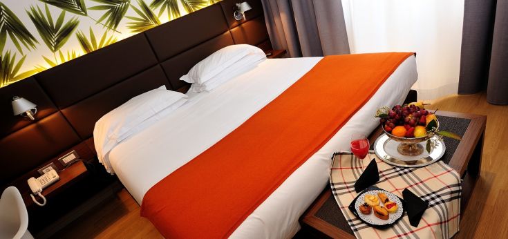 Cozy room with a bed, fresh fruit, simple decor, and well-maintained details.