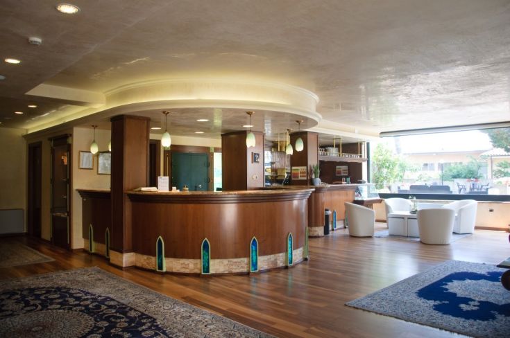 La reception di un hotel contemporaneo, con arredi semplici e un'atmosfera accogliente.