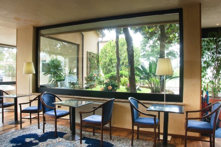 Una zona relax accogliente che si affaccia su un giardino ben curato, ideale per momenti di quiete.