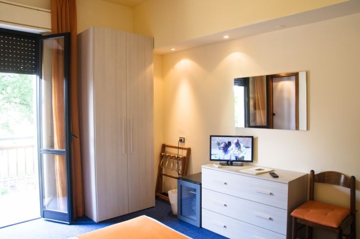 Camera dell'Hotel Le Grazie, semplice e confortevole, dotata di TV e affaccio su un balcone.