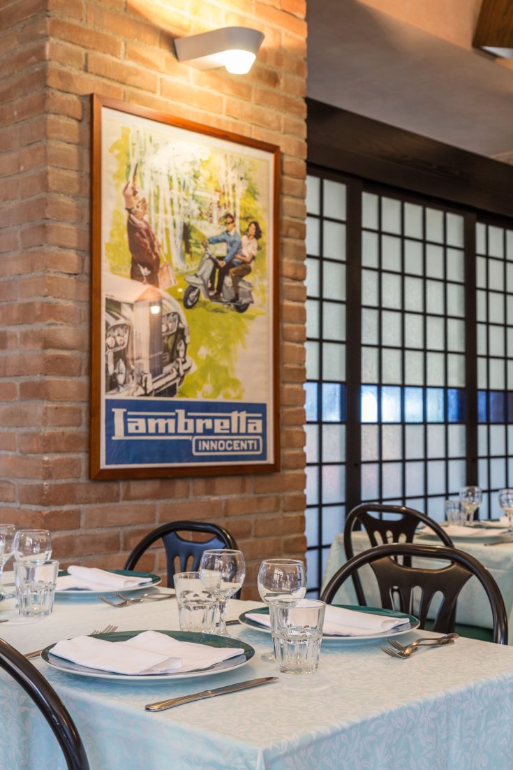 Interno del ristorante con tavoli ben apparecchiati e decorazioni in stile vintage.