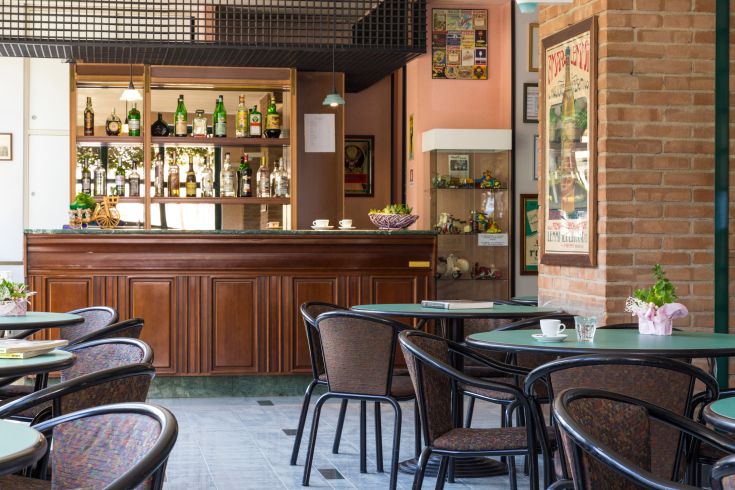 Una sala ristorante confortevole con tavoli sistemati e un bar ben attrezzato.