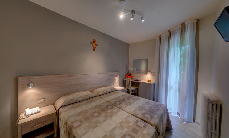 Camera semplice e confortevole con letti singoli e decorazioni minimaliste.