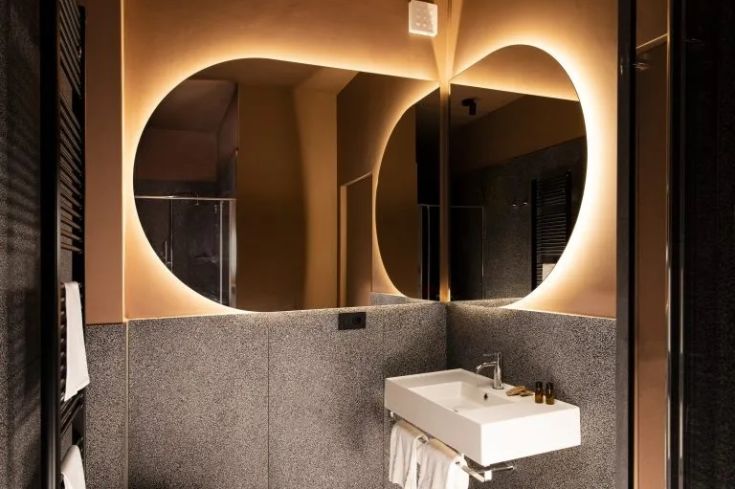 Zeitgemäßes Badezimmer mit einem beleuchteten Spiegel und einfachen Details, ideal für entspannende Momente.