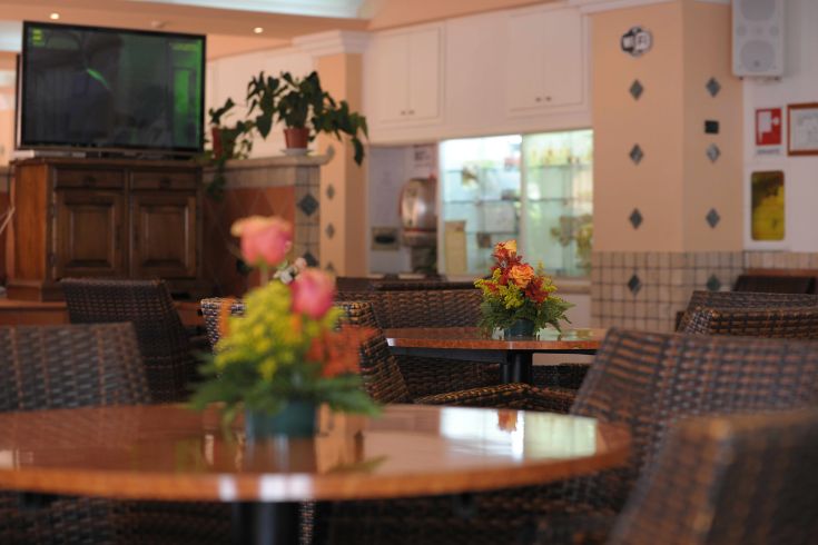 Un ristorante tranquillo con tavoli apparecchiati e fiori freschi, ideale per ritrovi conviviali.