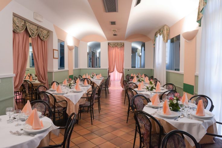 Sala ristorante con tavoli ordinati e un'atmosfera accogliente, adatta per pranzi o cene speciali.