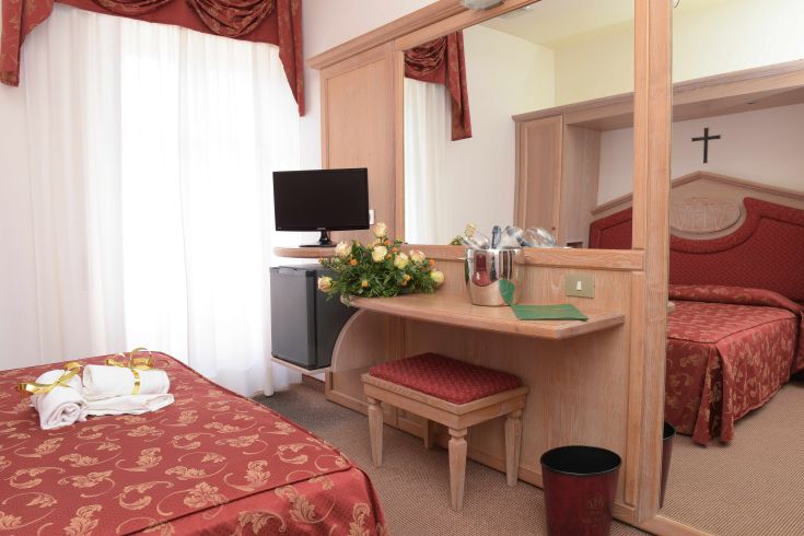 Camera accogliente con TV e minibar, decorata in modo semplice. Adatta per un soggiorno tranquillo.