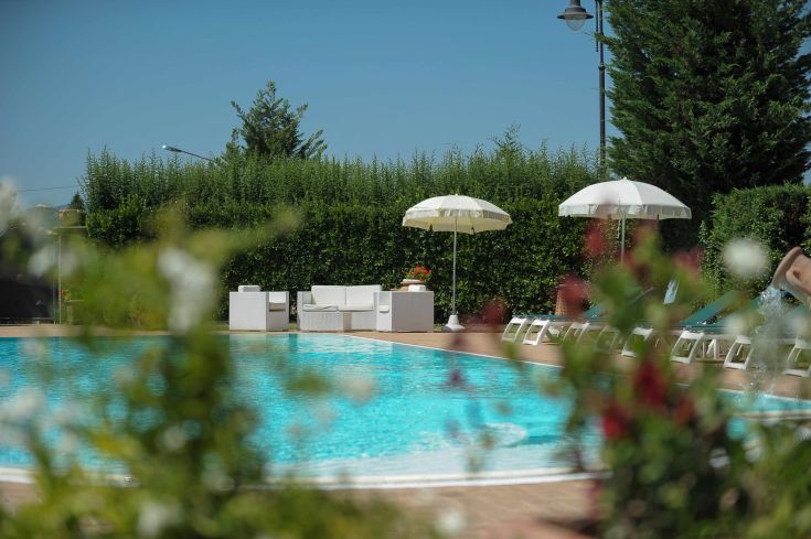 Una piscina in un contesto tranquillo, dotata di ombrelloni e lettini per rilassarsi.