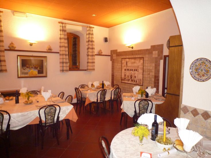 Interno di un ristorante, con tavoli ben disposti e decorazioni in stile rustico.