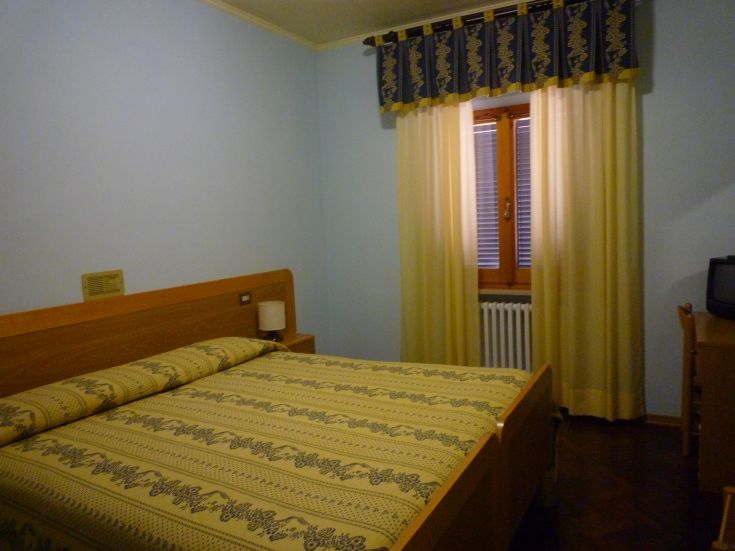 Camera confortevole con letto matrimoniale e arredi pratici, in un ambiente rilassante.