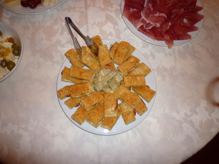 Un piatto di antipasti composto da crostini croccanti con una crema gustosa al centro.