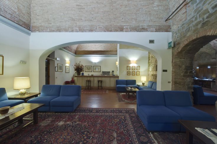 Entrée d'un hôtel situé dans un ancien bâtiment, avec des espaces spacieux et un décor sobre et confortable.