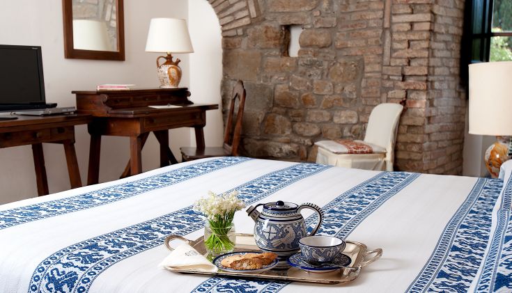 Chambre d'hôtel simple avec des meubles classiques et un service à thé sur le lit. Atmosphère conviviale.