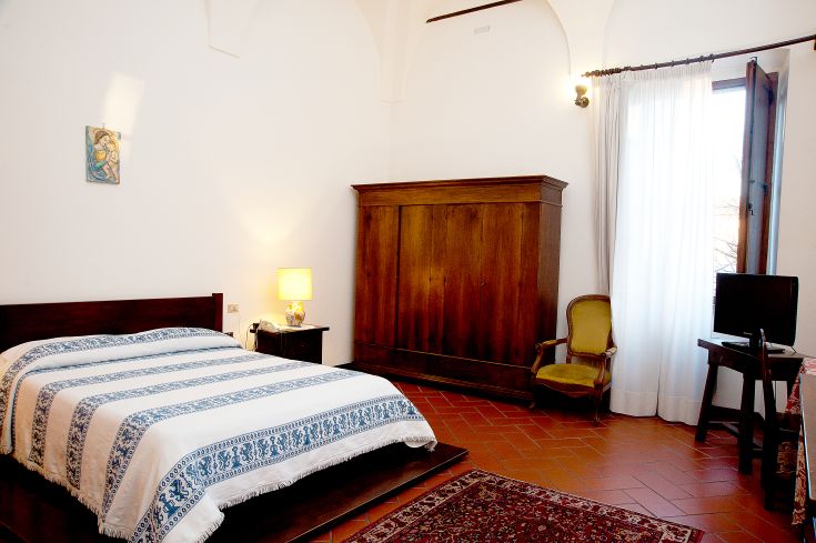 Une chambre d'hôtel paisible avec des meubles classiques et des équipements modernes, idéale pour un séjour confortable.