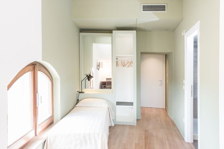 Simple space with a double bed, wardrobe, and plenty of natural light, perfect for a peaceful stay.