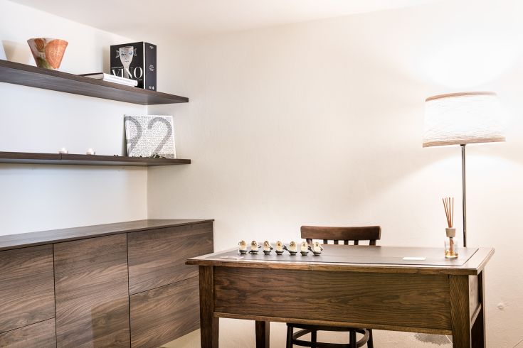 A simple resting corner with a wooden table and lamp, perfect for moments of tranquility.