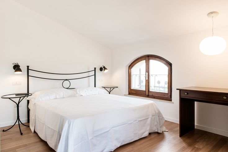 Bright and spacious double room with a large bed and wide windows.