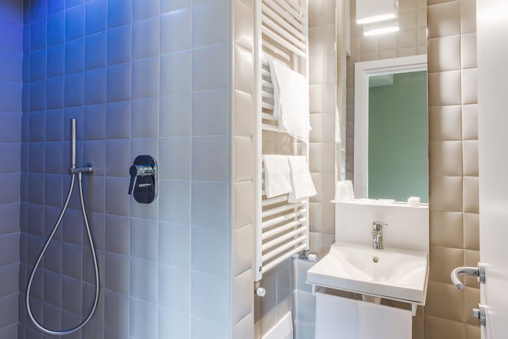 Modern bathroom with shower, mirror, and essential accessories. Soft lighting creates a cozy atmosphere.