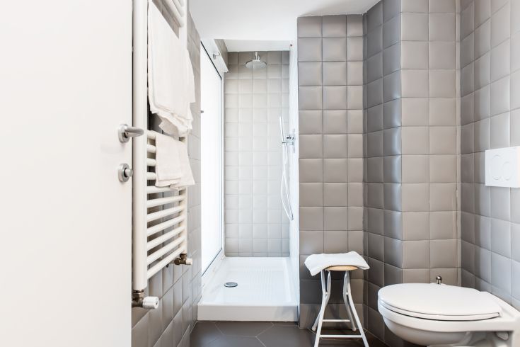 Contemporary bathroom with grey tiles and simple furnishings for a tranquil atmosphere.