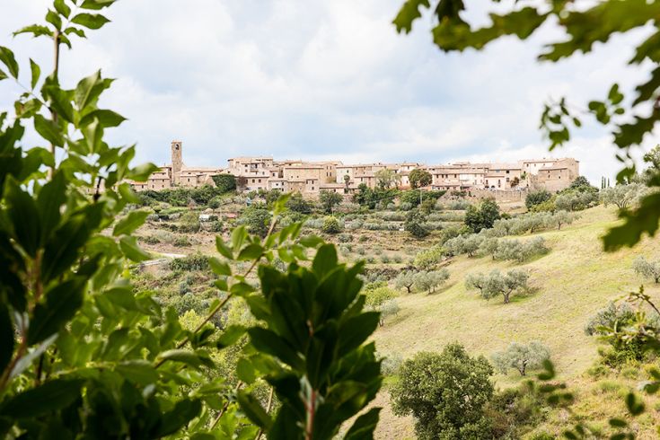 View of an Umbrian village surrounded by green hills, featuring ancient buildings.
