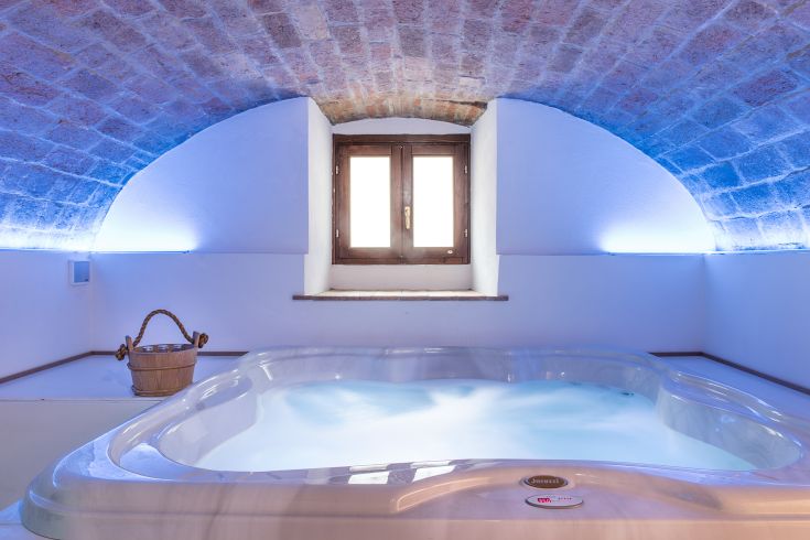 A jacuzzi located in a serene environment, ideal for relaxation, with soft lighting and comfort.