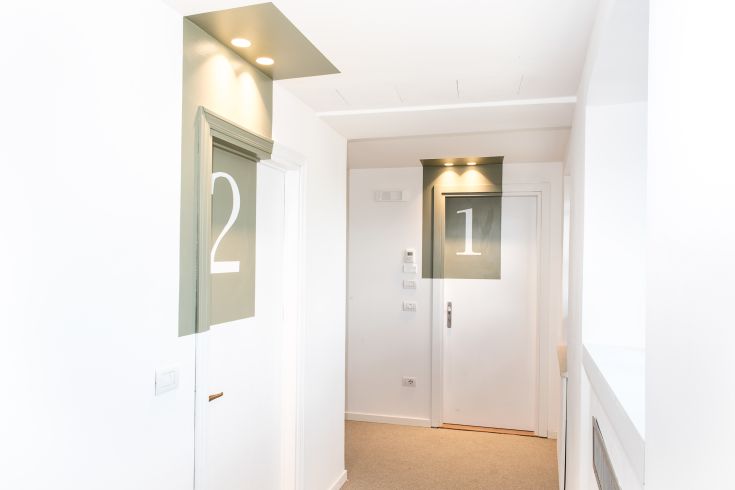 A spacious and well-lit hallway with numbered doors 1 and 2, suitable for a hotel.