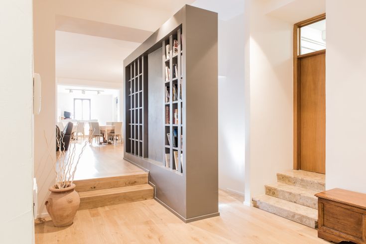 Bright environment featuring a bookshelf that separates spaces, furnished in a simple and functional style.