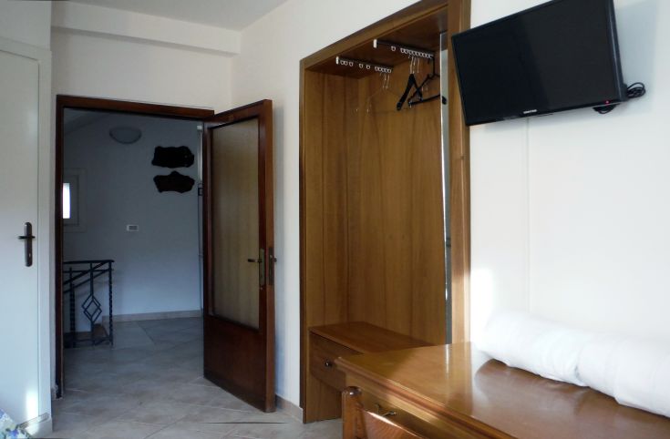 Camera accogliente in affitto, con TV e armadio. Arredamento semplice e funzionale.