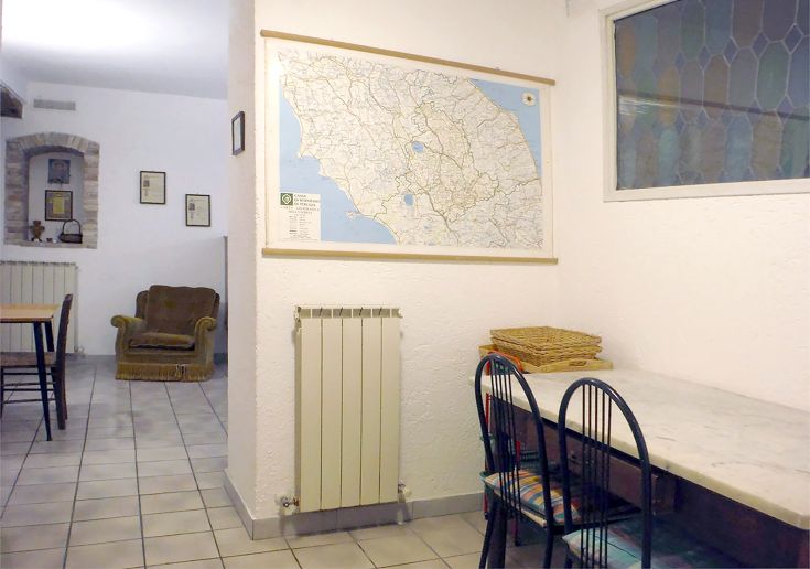 Interno semplice con un tavolo e una mappa della zona appesa alla parete.