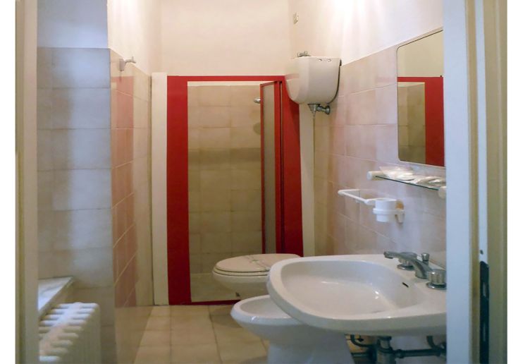 Bagno pratico con doccia, wc e lavandino, arredato in modo sobrio e funzionale.