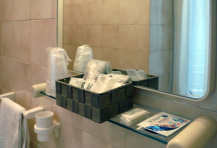 Un bagno con accessori da toeletta sistemati in un cesto, allestito per accogliere gli ospiti.