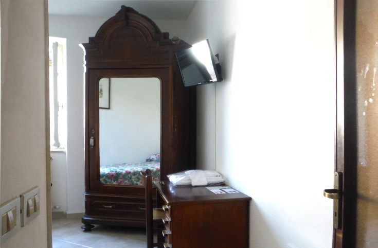 Ambiente accogliente in un palazzo storico, dotato di TV e mobili in legno scuro.