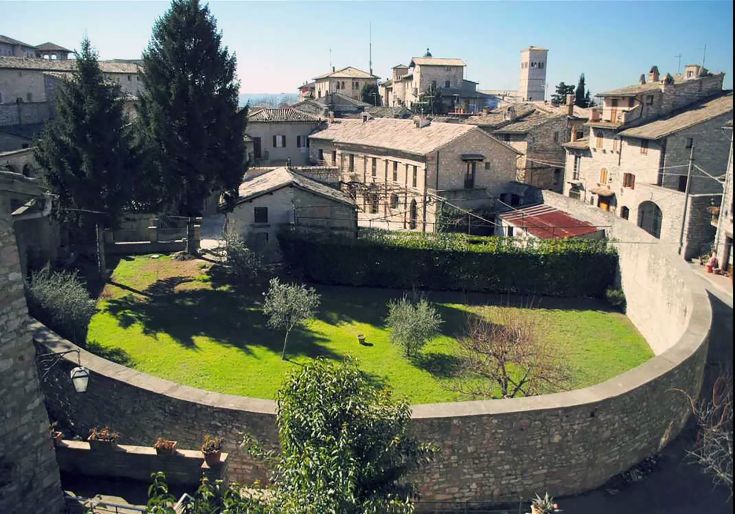 Panorama di un centro storico con spazi verdi e edifici storici, che riflettono l'architettura tradizionale.