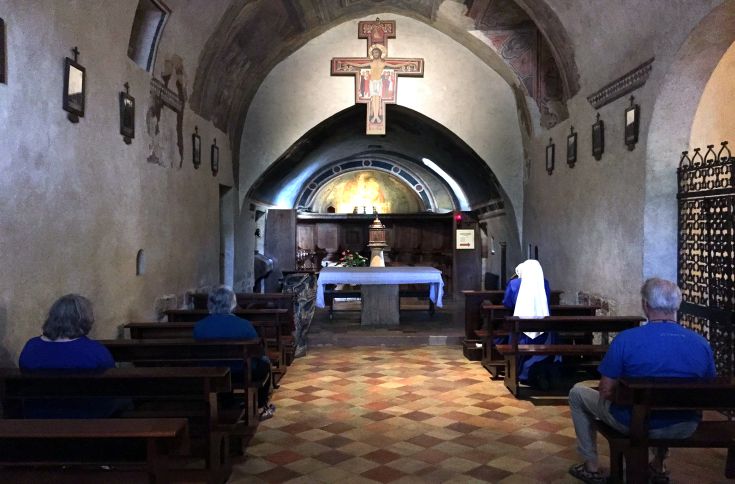 Interno di una chiesa con panche in legno, caratterizzato da un'atmosfera serena e di quiete.