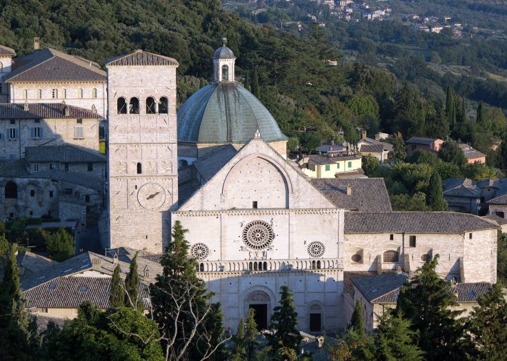 Panorama della Basilica di San Francesco ad Assisi, immersa nel verde e nella storia della città.