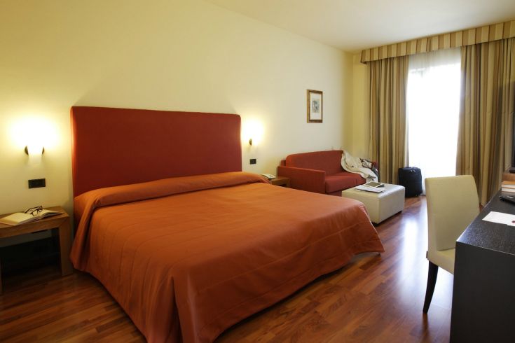 Camera moderna in un palazzo in Umbria, con letto matrimoniale e arredi sobri.