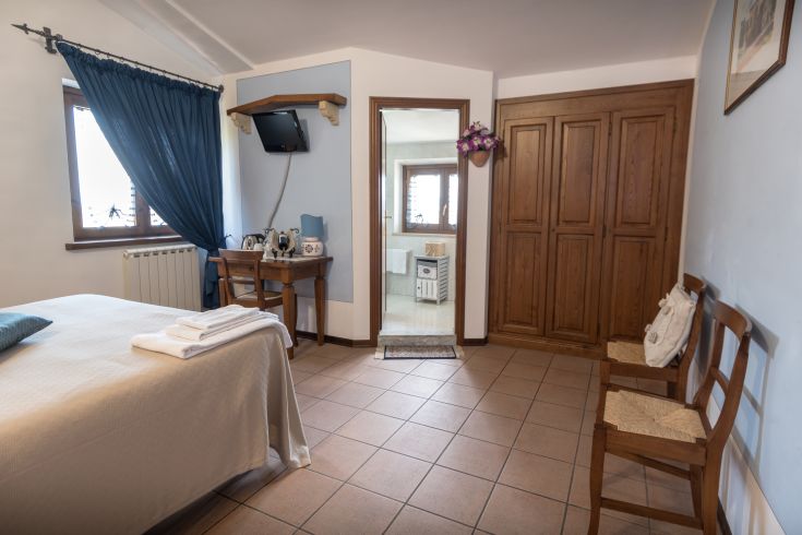 Camera confortevole e luminosa con bagno privato e panorama sulla campagna umbra.
