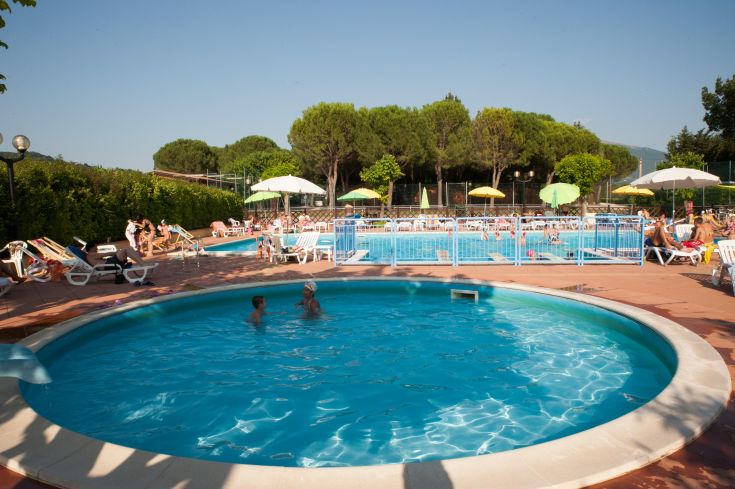 Un villaggio turistico circondato da spazi verdi, con aree per il relax, piscine e servizi adatti a famiglie e animali.