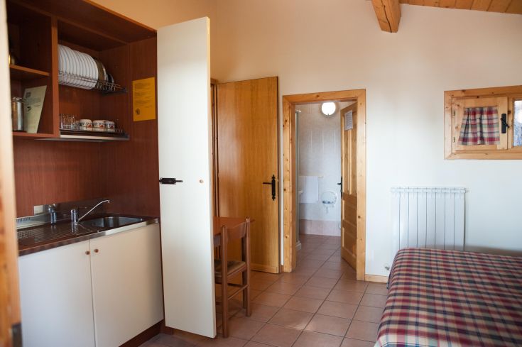 Interno di un appartamento semplice con cucina attrezzata e bagno accessibile.