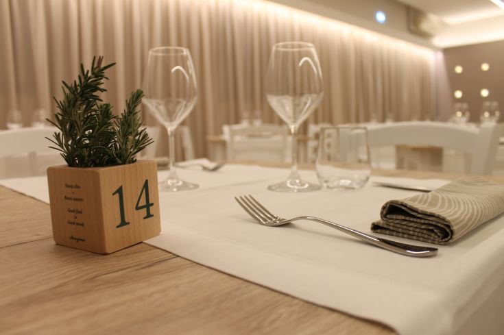 Un tavolo da ristorante con decorazioni semplici e bicchieri pronti per essere utilizzati.