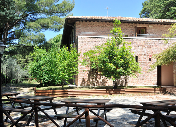 Steingebäude umgeben von Bäumen, ideal für Aufenthalte und Aktivitäten im Freien, eingebettet in die umbrische Natur.