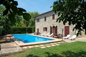 Agriturismo mit einem Pool, umgeben von Grünflächen, bietet einfache und geräumige Unterkünfte, ideal für einen kurzen Aufenthalt.