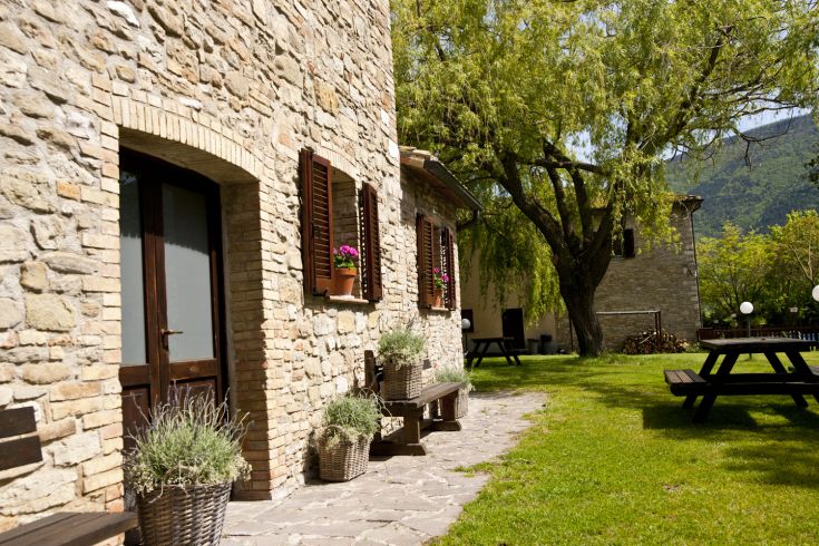 Agriturismo mit historischen Gebäuden, umgeben von weiten Grünflächen und gut gepflegten Gärten.