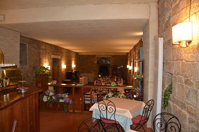 Innenansicht eines Restaurants mit Steinwänden und einfachen Tischen, geeignet für Gruppen und Familien.