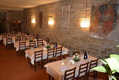 Ein Restaurant mit sorgfältig platzierten Tischen und Steinwänden, ideal für entspannte Abende in einer gemütlichen Atmosphäre.