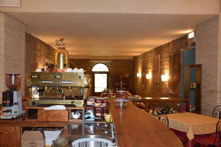 Ein gemütliches Café mit einfacher Einrichtung und einer gut ausgestatteten Theke, perfekt für eine Pause.