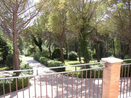 Ein Gebäude, das von einem gepflegten Park mit üppiger grüner Vegetation umgeben ist.